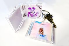 two cd cases sitting next to each other with keychains on top of them