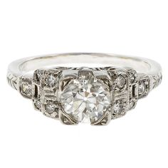 an antique style diamond ring with filigrees on the sides and side stones