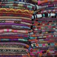 a large stack of colorful fabrics on display