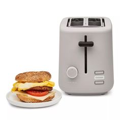 a toaster and a plate with a sandwich on it sitting next to each other