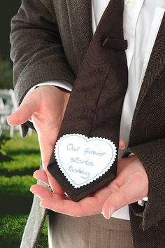 a man wearing a suit and tie holding a piece of paper that says our forever starts today