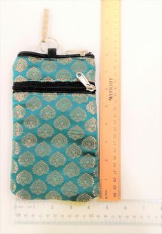 a zippered pouch sitting next to a ruler