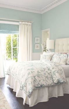 a bedroom with blue walls and white furniture