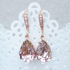 "Heatherly Designs dangling earrings made using genuine Swarovski® crystals in blush pink which dangle from rose gold plated brass french earring hooks with tiny inlaid cubic zirconia. ●Nickel free ●Earring Size (L x W): 1.25\" x 1/2\" or 32 x 14mm ●Swarovski® crystal color name(s): Vintage Rose ●Matching Necklace: http://etsy.me/1Og9wYm ●Arrives in our signature Heatherly gift box. Handmade with ❤ by Heather ● ● ● ● ● ● ● ● ● ● ● ● ● ● ● ● ● ● ● ● ● ● ● ● ● ● ● ● →Quantity Discounts listed belo Cubic Zirconia Bridal Earrings, Wedding Rose Gold, Wedding Rose, Nickel Free Earrings, Box Handmade, Dangling Earrings, Vintage Rose, Earring Hooks, Matching Necklaces