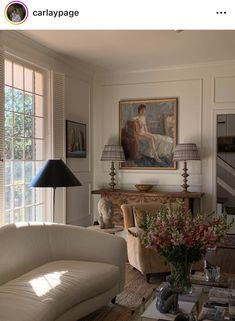 a living room filled with furniture and a painting on the wall