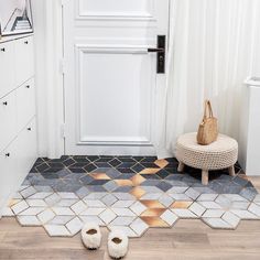 a pair of slippers sitting on the floor in front of a white door with geometric tiles