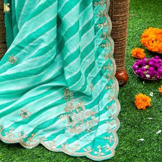 Experience the Enchantment: Elevate your style with our mesmerizing Green Leheriya Saree, a splendid fusion of tradition and opulence. This exquisite creation showcases the timeless allure of Zardozi and Aari Work, complemented by a charming scalloped border, making it a radiant addition to your wardrobe. A Timeless Addition: Ideal for weddings, special occasions, or festive celebrations, this Green Leheriya Saree with Zardozi and Aari Work is a symbol of timeless elegance and tradition. It capt Traditional Pre-draped Saree With Dori Work For Eid, Eid Pista Green Dola Silk Pre-draped Saree, Pre-draped Saree With Cutdana For Eid, Designer Festive Dupatta In Dola Silk, Festive Designer Dupatta In Dola Silk, Festive Dola Silk Dupatta For Designer Wear, Semi-stitched Dola Silk Anarkali Set For Traditional Ceremonies, Festive Designer Traditional Wear With Cutdana, Georgette Anarkali Set For Traditional Ceremonies During Diwali