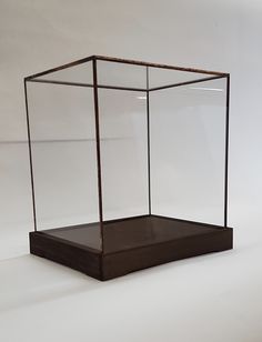 an empty glass box sitting on top of a white surface with no one in it