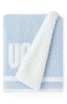 a blue and white towel with the letter u on it's side, folded up