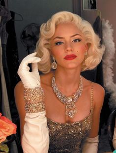 a woman with blonde hair wearing a gold dress and white gloves