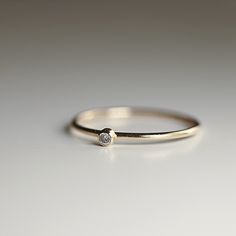 This dainty minimalist diamond ring is perfect for wearing alone or mixing and matching with your other rings. Tiny wedding band for women. ***Band : 18 gauge ( 1 mm) 14k solid yellow gold ***Diamond : 2mm round brilliant cut 0.03ct ***Diamond is I color SI clarity ***Bezel setting. Please ask me different size and carat diamond. Please choose your ring size and material from drop down menu. Meltem ♥ --------------------------------------- FOLLOW ME HERE: Instagram: @meltmjewelry Pinterest: www. Minimalist Stackable Rings With Round Diamond Band, Minimalist Diamond Stackable Rings With Round Band, Minimalist Midi Rings With Diamond Accents, Minimalist Everyday Diamond Ring With Round Cut, Everyday Minimalist Round Cut Diamond Ring, Everyday Minimalist Diamond Ring, Minimalist Stackable Rings With Diamond Accents, 14k Gold Stackable Rings With Single Diamond For Everyday, White Gold Stackable Rings With Single Diamond For Everyday