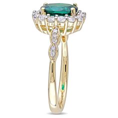 a gold ring with an emerald and white diamonds on the side, set in 18k yellow gold