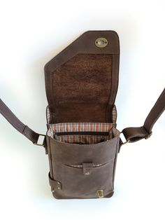 the inside of a brown leather bag with two compartments and one compartment that is open