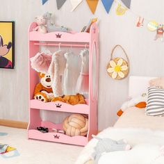 a pink shelf with stuffed animals on it in a child's playroom area