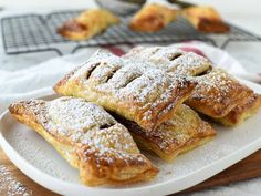 several pastries on a white plate with powdered sugar