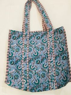 a blue and pink bag sitting on top of a white table