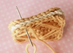 there is a yarn ball and needles on the pink tablecloth with polka dotes