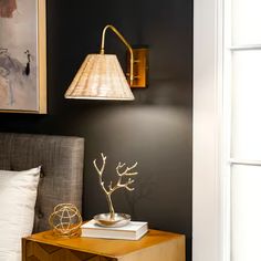 a bedroom with a bed, lamp and pictures on the wall