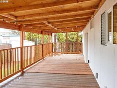 a covered porch with wooden floors and white walls