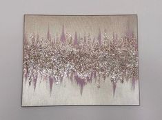 an abstract painting with silver and pink colors on a white background is hanging up against a wall