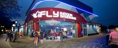 people are standing outside the entrance to an indoor shopping center at night time with lights on