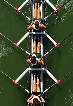 four people on a boat in the middle of water with their feet up and one person upside down