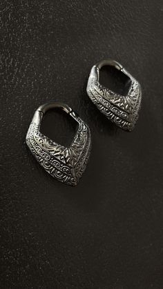 Adorn yourself with a pair of these striking black Viking-inspired ear weights, crafted for those with tunnales. Each piece exudes the rugged elegance of Norse craftsmanship, featuring intricate ornamental designs reminiscent of Viking artistry. Channel the spirit of the ancient Norse warriors as you wear these bold earrings, symbolizing strength, courage, and adventure. With their sleek black finish and intricate detailing, these earrings are sure to make a statement, whether you're exploring the modern world or sailing the seas of history. Comfortable and easy to wear all day the ear hangers are perfect to make sure the ear stretches throughout the day. It feels sturdy and won't accidentally fall off.  Length: 4cm Weight: 36g / 1.26oz Additional info: Come in a pair of two, Stainless Ste Bohemian Black Jewelry With Internally Threaded Details, Black Engraved Jewelry For Festivals, Black Engraved Jewelry For Festival, Nickel-free Black Plug Earrings For Festival, Nickel Free Black Plug Earrings For Festival, Handmade Black Metal Cartilage Earrings, Black Viking, Art Viking, Ear Hangers