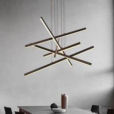 a modern chandelier hanging over a dining room table