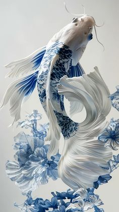 a white and blue fish floating on top of water next to some flowers in front of a gray background