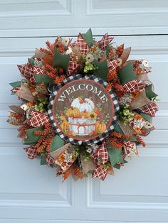 a welcome wreath hanging on the front door with pumpkins, leaves and other decorations