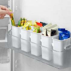 a refrigerator door is open with food and drinks in containers on the shelf next to it