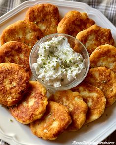 a white plate topped with potato cakes and cream