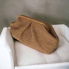 a knitted purse sitting on top of a white chair next to a gray wall