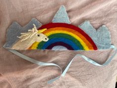 a felt unicorn headband with a rainbow in the background