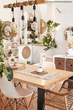 a dining room table and chairs with plants on the wall behind them in front of a mirror