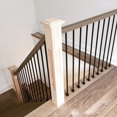 an empty room with wood floors and white walls, along with wooden handrails