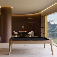 a billiard table in the middle of a room with large windows looking out on mountains