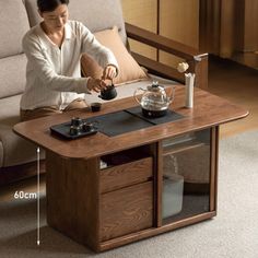 a woman sitting at a coffee table pouring tea