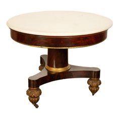 a round table with marble top and gold accents