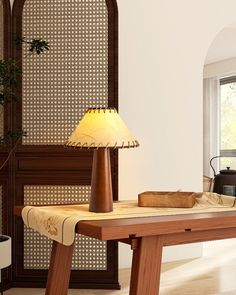 a wooden table with a lamp on it in front of a window and a wall