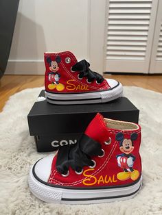 red mickey mouse high top sneakers with black bows and name on the side, sitting on a white rug