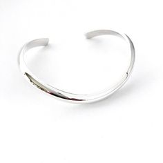 This solid sterling silver curved bracelet cuff has a polished finish with a high dome half round edge. It is an elegant and timeless design. I have shaped the bracelet cuff so it fits the natural curve of your wrist and sits very comfortably on your hand particularly when you are writing or using a computer. The bracelet cuff curves down at the front and you simply slide it across the wrist approximately where you would wear your watch.  I have used a very heavy gauge metal so it will not go ou Classic Cuff Bracelets With Polished Finish, Classic Open Band Cuff Bracelet With Polished Finish, Timeless Silver Cuff Bangle, Modern Sterling Silver Cuff Bracelet With Polished Finish, Timeless Silver Bangle Cuff Bracelet, Silver Open Cuff Bracelet With Polished Finish, Modern Sterling Silver Open Cuff Bangle, Modern White Gold Cuff Bracelet With Shiny Finish, Modern Shiny Cuff Bangle Bracelet