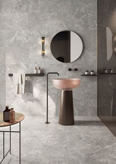 a bathroom with a sink, mirror and towel rack in grey marbled stone wall