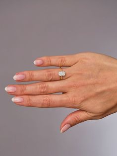 a woman's hand with a diamond ring on it