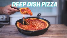 a deep dish pizza being lifted from a skillet