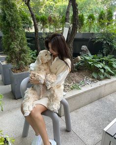 a woman sitting on a bench holding a dog