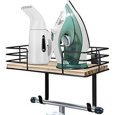 an ironing board with two irons on it next to a green and white electric iron