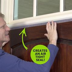 a man holding his hand up to an air tight seal on the side of a door