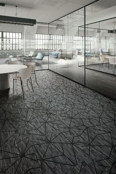 an empty conference room with chairs and tables in front of glass partitions that reflect light