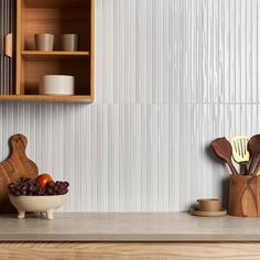 a kitchen counter topped with wooden utensils and fruit